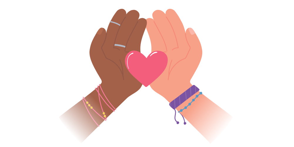 A brown-skinned hand and a light-skinned hand hold a single heart together
